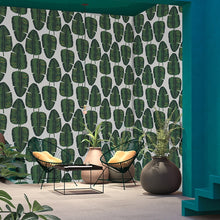 Load image into Gallery viewer, Tropical green and gold banana leaf patterned wallpaper decorating a room