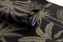Load image into Gallery viewer, Detail of tropical designed non woven wallpaper illustrated with gold palm trees on a black background
