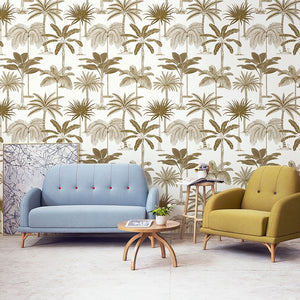 Living room wall with tropical non woven wallpaper illustrated with golden palm trees on a white background