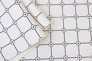 Detail of black and white grid patterned vinyl wallpaper with flower motif