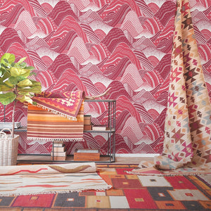 Stylized pink rolling mountain patterned non woven wallpaper in a room with contemporary textile decor